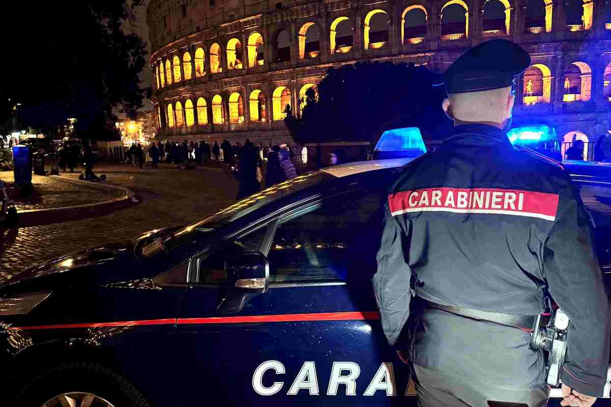 Carabiniere di spalle con macchina dei carabinieri e sullo sfondo il Colosseo